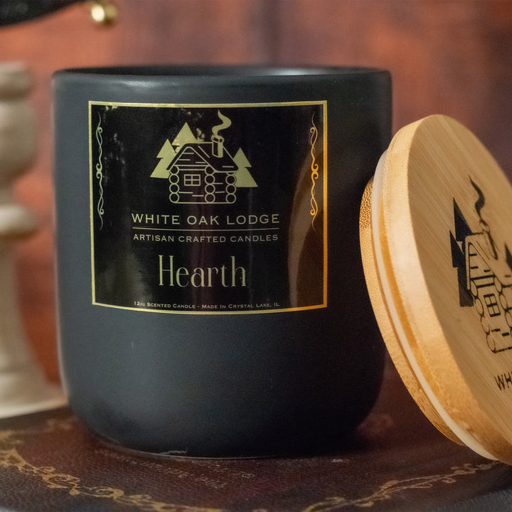 Hearth, 12oz Jar Candle, Winter Cabin Fireplace Scented, Front View with Lid Removed on Books