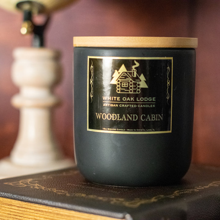 Woodland Cabin, 12oz Jar Candle, Floral Juniper Scented, Front View on Old Books